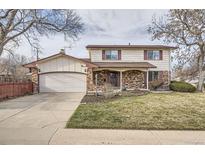 Charming two-story home with an attached two-car garage, brick accents, and a well-maintained lawn at 12235 W 61St Ave, Arvada, CO 80004