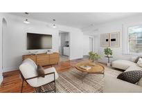 Bright living room boasts hardwood floors, a modern media center, and a cozy seating area at 1570 Xanthia St, Denver, CO 80220