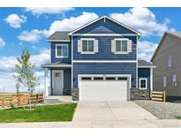 Charming two-story home featuring blue siding, white trim, and a well-manicured front lawn at 17959 Dandy Brush Ln, Parker, CO 80134