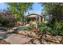 Charming home featuring a well-maintained yard with stone accents and landscaping, creating an inviting curb appeal at 1633 Gaylord St, Denver, CO 80206