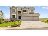 Charming two-story home featuring a three-car garage and a well-manicured front lawn at 6950 Blue Mesa Ln, Littleton, CO 80125