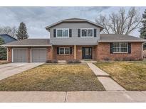 Charming two-story home with brick and gray siding, well-manicured lawn, and an attached two-car garage at 3673 E Nichols Ave, Centennial, CO 80122