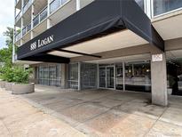 Condominium building entrance featuring a covered entrance with glass doors and planters outside at 888 N Logan St # 2C, Denver, CO 80203