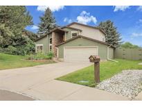 Charming home featuring stone accents, a well-manicured lawn, and a two-car garage at 12671 W Dakota Dr, Lakewood, CO 80228
