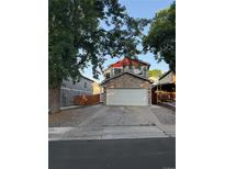 Two-story home featuring a stone facade over the garage and red trim against a mature tree canopy at 8057 Bryant St, Westminster, CO 80031
