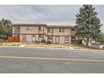 A charming two-story townhome features a neutral exterior, a small porch, and a well-maintained front yard at 8770 Rainbow Ave # B4, Denver, CO 80229