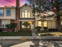 Charming two-story townhome with brick and siding exterior, showcasing a well-maintained front yard at 9618 W Chatfield Ave # E, Littleton, CO 80128