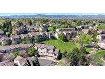 Scenic aerial view of townhomes with lush green spaces and mountain views in the distance at 6809 S Webster St # F, Littleton, CO 80128