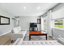 Bright living room features light gray walls, wood flooring, and access to the backyard at 9175 Cole Dr, Arvada, CO 80004