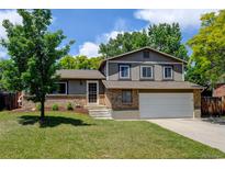 Charming two-story home with a well-maintained lawn and mature trees on a sunny day at 6775 Coors Ct, Arvada, CO 80004