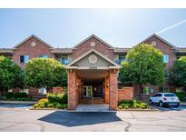 Inviting brick building entrance with well-maintained landscaping and convenient parking at 2895 W Riverwalk Cir # 104, Littleton, CO 80123