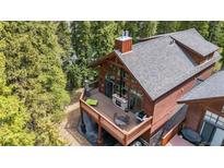 Stunning home exterior featuring a spacious deck with a fireplace and outdoor seating at 960 Whispering Pines Ln, Breckenridge, CO 80424