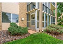 Exterior showing a building with enclosed lanai, landscaping and stone accents at 3022 S Wheeling Way # 109, Aurora, CO 80014