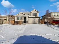 Two-story house with snow-covered yard, attached garage, and neutral color scheme at 25643 E Bayaud Ave, Aurora, CO 80018