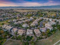 Stunning aerial view of a suburban neighborhood nestled against a picturesque mountain range, indicating a desirable location at 673 Tiger Lily Way, Highlands Ranch, CO 80126