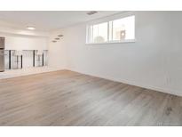 Spacious living room featuring light wood floors and large window at 7335 E Quincy Ave # 104, Denver, CO 80237