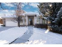 Two-story house with a white exterior, stone accents, and a three-car garage at 60 Golden Eagle Rd, Greenwood Village, CO 80121