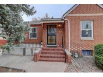 Inviting front door of brick home with covered porch and decorative security gate at 4850 E 18Th Ave, Denver, CO 80220