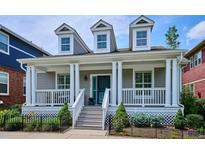 Charming home featuring a welcoming front porch, dormer windows, and well-manicured landscaping at 2723 Galena St, Denver, CO 80238