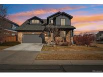 Charming two-story home featuring a stone facade, attached garage, and landscaped front yard at 25123 E 5Th Ave, Aurora, CO 80018