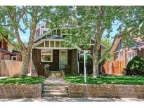 Charming brick home with well-manicured lawn and mature trees offering shade and curb appeal at 2683 Bellaire St, Denver, CO 80207