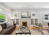Bright living room showcasing a decorative fireplace, hardwood floors, and modern furnishings at 2683 Bellaire St, Denver, CO 80207