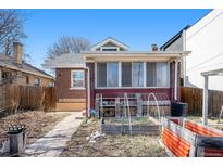 Red brick home with a small garden and covered patio in the backyard at 2921 N Fillmore St, Denver, CO 80205