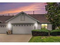Charming home with a two-car garage, well-manicured lawn, and beautiful twilight sky at 7611 S Addison Way, Aurora, CO 80016