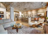 Bright living room with concrete ceiling, brick wall, light wood floors, and modern furniture at 1801 Wynkoop St # 401, Denver, CO 80202