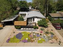Charming home with xeriscaped yard featuring colorful succulents and modern fence at 2545 S Lowell Blvd, Denver, CO 80219