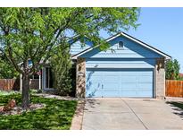 Charming light blue home featuring a two-car garage, well-maintained lawn, and inviting curb appeal at 3715 E 139Th Pl, Thornton, CO 80602