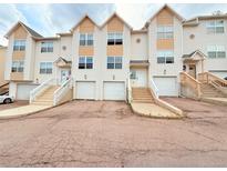 View of townhomes with a private garages and steps leading up to the front doors at 94 Vale St, Palmer Lake, CO 80133