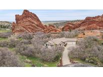 Secluded home with tile roof situated amongst mature trees and monumental red rock formations creates a natural hideaway at 5688 Red Fern Ct, Littleton, CO 80125