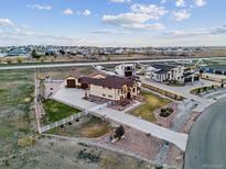 Expansive property with a modern home, white fencing, landscaping and long driveway at 16101 Iola St, Brighton, CO 80602