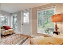 Inviting living room featuring bright windows, cozy seating, and wood floors at 4642 Plettner Ln, Evergreen, CO 80439