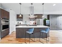 Modern kitchen boasts a large island with seating and stylish stainless steel appliances at 3201 W 25Th Ave, Denver, CO 80211