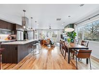 Open floor plan showcasing the kitchen, dining, and living area with hardwood floors and natural light at 3201 W 25Th Ave, Denver, CO 80211