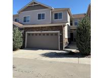 Charming two-story townhome with a stone facade and attached garage at 14883 E Crestridge Dr, Centennial, CO 80015
