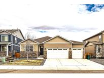 Charming single Gathering home with a two car garage, stone accents, and well manicured lawn at 14758 Normande Dr, Mead, CO 80542