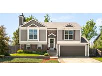 Charming two-story home with gray siding, brick accents, and well-manicured landscaping at 1140 Devonshire Ct, Lafayette, CO 80026