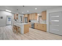 Bright kitchen with stainless steel appliances, wood cabinets, and a large island with a white countertop at 328 Quay St, Lakewood, CO 80226