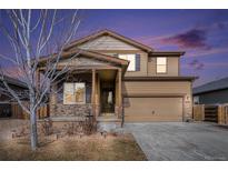 Charming two-story home featuring stone accents, neutral color palette, and an attached two-car garage, enhanced by a beautiful sunset at 1788 Taos St, Brighton, CO 80603