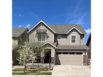 Charming two-story home featuring a two-car garage, stone accents, and blossoming tree in the front yard at 2305 Prospect Ln, Broomfield, CO 80023