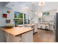 Bright kitchen featuring wood countertops, stainless steel appliances, pendant lighting, and a large window with scenic views at 6621 E Peakview Pl, Centennial, CO 80111