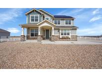 Charming two-story home featuring stone accents, solar panels, and a well-maintained front yard with gravel at 16360 Paris Way, Brighton, CO 80602