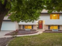 Charming home featuring a well-maintained lawn, garden beds and brick accents at 13055 E Dakota Ave, Aurora, CO 80012