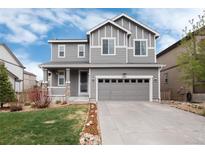Charming gray two-story home with a well-manicured lawn and attached two-car garage at 7844 Grady Cir, Castle Rock, CO 80108