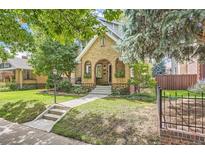 Charming brick home with landscaped front yard and inviting entryway with decorative brickwork and a well manicured lawn at 543 S Vine St, Denver, CO 80209