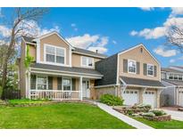 Charming two-story home featuring a covered porch, two-car garage, and well-manicured lawn in a suburban neighborhood at 6340 E Costilla Pl, Centennial, CO 80112
