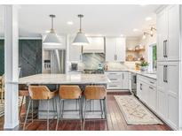 Bright kitchen featuring an island with seating, marble countertops, and stainless steel appliances at 6340 E Costilla Pl, Centennial, CO 80112